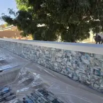 Backsplash — Stone-look tile under a poured cap.